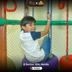 A boy tests his strength and coordination on the tire swing, part of our indoor ninja course. This area is designed for older kids looking for a bit more of a challenge.