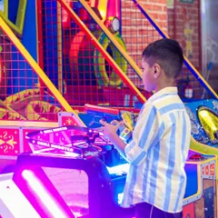 A boy takes aim at the "Skill Shooter" arcade game. It's a fun challenge for those with a competitive spirit.