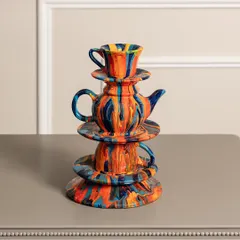 Inspired by Alice in Wonderland, this stacked teapot and teacup sculpture is a whimsical conversation starter. The vibrant, marbled paint effect gives it a playful energy, perfect for a coffee table or a kitchen shelf.