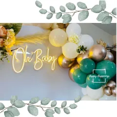 A close-up of our popular "Oh Baby" neon sign against a backdrop of green and gold balloons. This glowing detail adds a trendy and celebratory touch to any modern baby shower decor.