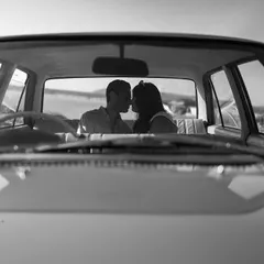 A black and white shot through a car windshield creates an intimate, voyeuristic feel. It’s a cinematic technique that makes this simple kiss feel like a pivotal scene in a love story.