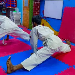 Flexibility is key in Taekwondo. A student demonstrates a full split during a conditioning session.