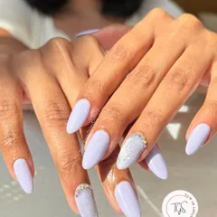 A chic and elegant lavender nail set. The solid color is beautifully accented with a textured "sugar" glitter nail and delicate crystal placements at the cuticle.