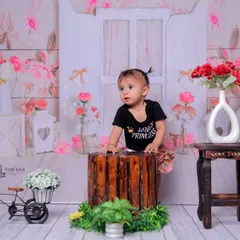 Standing tall like a little princess. This shot captures a milestone moment of the baby supporting herself, framed by the lovely floral backdrop.