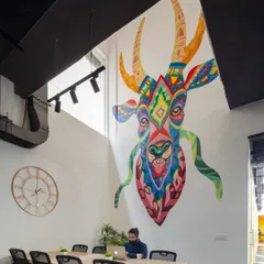 A large, colorful mural serves as a powerful focal point in this open work area. We use large-scale art to inject personality and energy into our office designs, turning a simple wall into a source of inspiration.