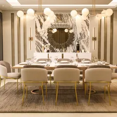 This view highlights the stunning marble accent wall and sunburst mirror, creating a dramatic and luxurious focal point in the dining area.