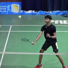 A young player poised at the net, ready to intercept the shuttle. Quick reflexes and net dominance are critical skills we develop.
