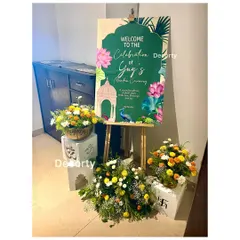 A custom welcome sign for a Mundan ceremony, designed with traditional Indian motifs like lotuses and peacocks. The entrance is decorated with fresh floral arrangements to greet guests.