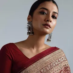 This is a royal inspired look from a professional photoshoot, featuring dramatic smokey eyes and a perfectly blended, matte base. The hair is styled in a sleek, low bun to complete the regal and powerful aesthetic.
