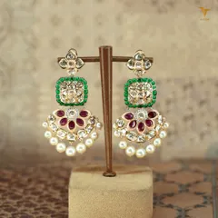 These statement polki earrings are a celebration in themselves. With vibrant emerald and ruby accents, shimmering uncut diamonds, and delicate pearls, they are the perfect blend of tradition and glamour.