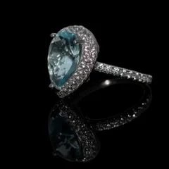 A true showstopper, this statement cocktail ring features a large, teardrop-shaped aquamarine-colored stone surrounded by a halo of sparkling zirconia. Crafted in pure 92.5 silver, it's designed for those special events where you want your jewelry to make an impact.