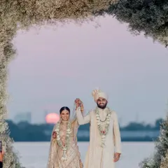 An eternal love, sealed with vows under the sunset sky in Kochi. Even the sun made a special appearance, casting a radiant glow upon this ethereal white floral mandap, adding the perfect touch to a magical sunset wedding.