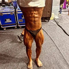 A close-up of the incredible abdominal and leg definition achieved during the 8-week prep. This is the level of conditioning required to win.