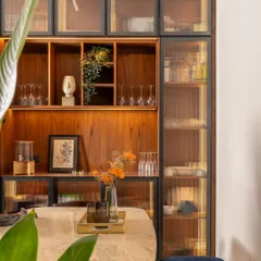 A close-up of the dining area's crockery unit, featuring reeded glass doors and warm internal lighting that beautifully displays the items within while maintaining a clean look.