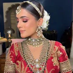 This Sabyasachi bride wanted a traditional yet clean look. I created a sleek center-parted bun wrapped in a classic white gajra, a timeless choice that exudes grace and sophistication for a wedding ceremony.