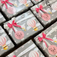 These beautifully wrapped baby announcement gifts, with a hot air balloon theme, are a whimsical way to share your news. The soft grey and pink colour scheme is perfect for celebrating a baby girl.