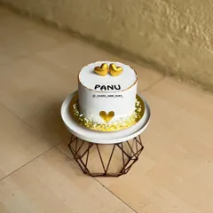 An aesthetic love-themed cake with golden hearts, simple and elegant.