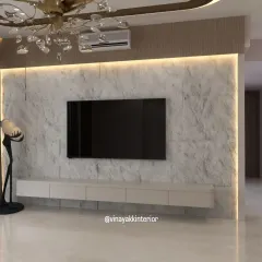 A TV unit can be a powerful design statement. This floating console is set against a textured, marble-finish wall with LED backlighting, creating a focal point that is both functional and incredibly chic. The design keeps the living area feeling open and clutter-free.