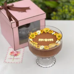 A hug in a bowl for Mother's Day. This is our handcrafted dark chocolate mousse, delicately decorated with fresh yellow and white blooms and the word "mom" in white chocolate. It comes packaged in our pink window box.