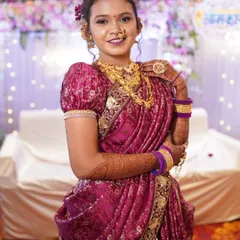 A closer look at the bridal ensemble, showing the layers of gold jewellery, the traditional nath, and the intricate design of the magenta saree.