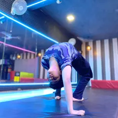 This student demonstrates a deep backbend, a testament to consistent flexibility training. This pose, also known as a bridge or wheel pose, is fundamental for many gymnastic skills.