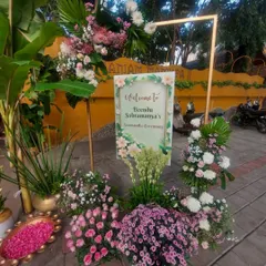 A beautiful welcome sign for the Seemantham ceremony, framed with an abundance of fresh pink and white flowers, setting a soft and celebratory tone.