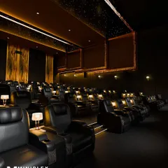 The side view of the multiplex highlights the spacious layout and the warm, inviting atmosphere created by the custom lighting.