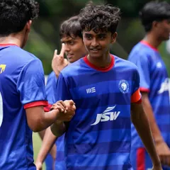 Teammates congratulate a player after a goal. Success is a team effort, and we celebrate our victories together.
