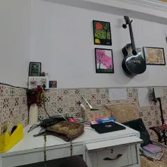 A corner of my studio, with my desk, art supplies, and the guitar my mehndi earnings bought me. Every object in this room tells a story of passion and hard work.