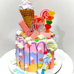This colorful candy theme cake is loaded with treats inside and out. The design features a real ice cream cone, lollipops, and marshmallows, with a mixed fruit flavor inside.