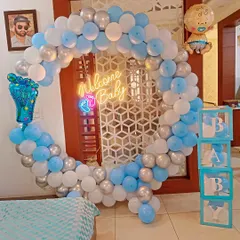 I create stunning welcome home decorations for baby boys, like this full balloon ring in shades of blue, white, and silver. The setup is completed with a "Welcome Baby" neon sign, "BABY" display boxes, and themed foil balloons.