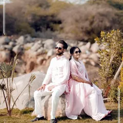 A cool, relaxed portrait of the couple sitting back-to-back, enjoying a quiet moment during their Haldi event.