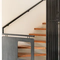 A minimal staircase design featuring wooden treads and sleek steel railings. This combination of materials offers a perfect balance between warmth and industrial aesthetics.