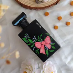 This perfume bottle is adorned with a hand painted pink bow and delicate botanicals. The ribbon design adds a graceful flow and a touch of classic charm, making it a truly unique and beautiful piece.