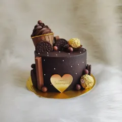A rich, dark chocolate anniversary cake. This design is loaded with various chocolates and a mini chocolate cupcake on top.