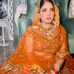 A full view of the orange fall bride. The rich colors of the lehenga are beautifully complemented by the intricate details of the rental jewelry set.