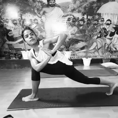 A student demonstrates Parivrtta Parsvakonasana (Revolved Side Angle Pose). This deep twisting lunge detoxifies the organs, improves balance, and builds immense strength.