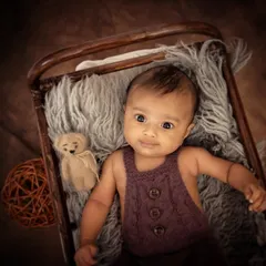 Even in a more rustic setup, we can capture beautiful awake moments. This baby is looking directly at the camera, giving us a glimpse of his calm and gentle personality.