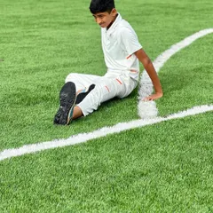 Taking a moment to rest and stretch on the field. I teach players the importance of listening to their bodies and properly recovering during and after training.