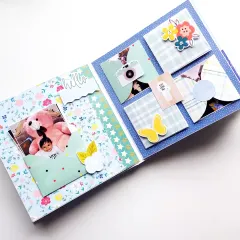 This page from the baby boy scrapbook has pockets for photos and sweet embellishments like a butterfly and "hello" tag.