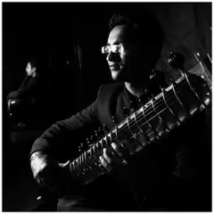 A reflective black and white portrait taken in Russia. The mirror image symbolizes the introspective nature of Indian classical music.