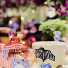 This detailed shot focuses on the elegant ginkgo leaf mug and a 'Home Sweet Home' card, emphasizing the cozy and personal nature of our housewarming gifts.