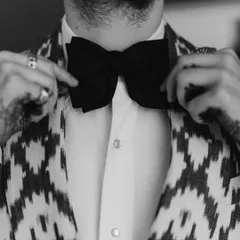 A close-up on the groom's bow tie. This black and white detail shot captures the texture and classic style of his getting-ready process, a nod to timeless elegance.