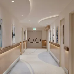 We transform sterile hospital corridors into pathways for healing. This ICU corridor uses gentle, curved ceiling details, soft, indirect lighting along the handrails, and calming wall art to create a soothing journey through the space, reducing the typical anxiety associated with hospital environments.