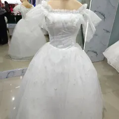 A classic fairytale bridal gown. This white off-shoulder ball gown is crafted from sparkling tulle and features romantic ruffled sleeves for a soft, dreamy look.