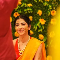 The bride's beautiful smile during her Haldi ceremony. I captured this candid moment through a frame of yellow, focusing on her genuine happiness.