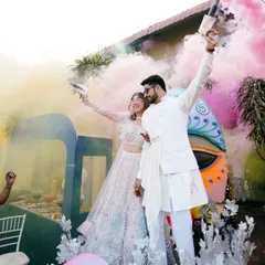 Let the celebrations begin. A Haldi ceremony is full of life, and I love capturing the energy with vibrant shots like this, using color smoke to frame the couple's grand entrance and kick off the festivities with a bang.