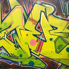 A close-up shot of the graffiti lettering. You can see the details of the spray can work, including the clean lines, color fades, and graphic elements like dots and highlights.