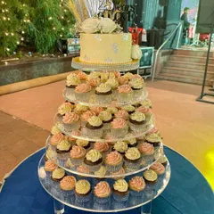A full view of the 25th-anniversary celebration setup, featuring my custom cake and a tower of matching cupcakes. It creates such a stunning dessert display.