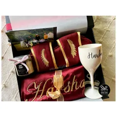 The ultimate luxury experience for the bride-to-be. This hamper features a personalized satin robe and slippers, a custom wine glass, and a 'Love Story' scented candle.